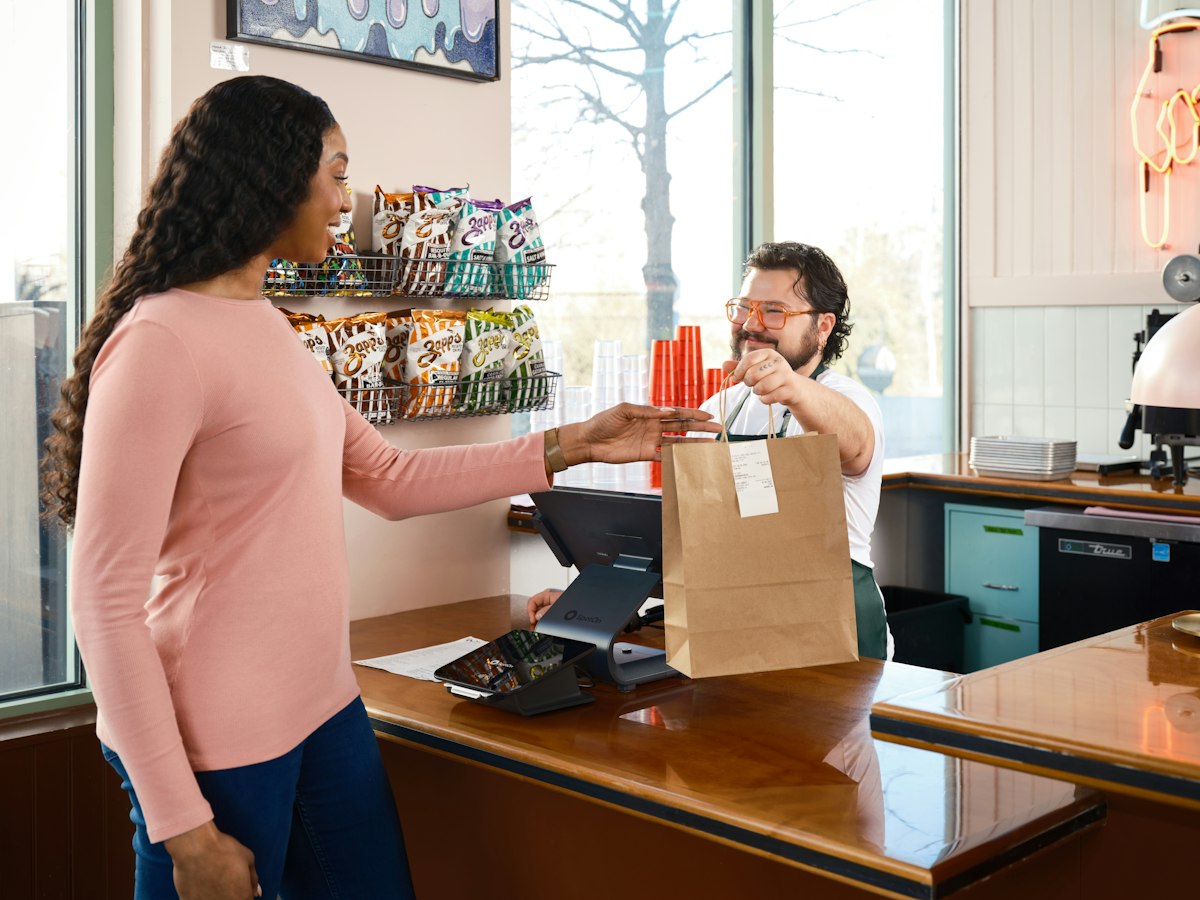 Client récupérant sa commande à emporter au comptoir d'un commerce